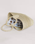 Rosita Palm Straw Tote: Hand-woven natural palm fiber tote with circular handles, light straw color.