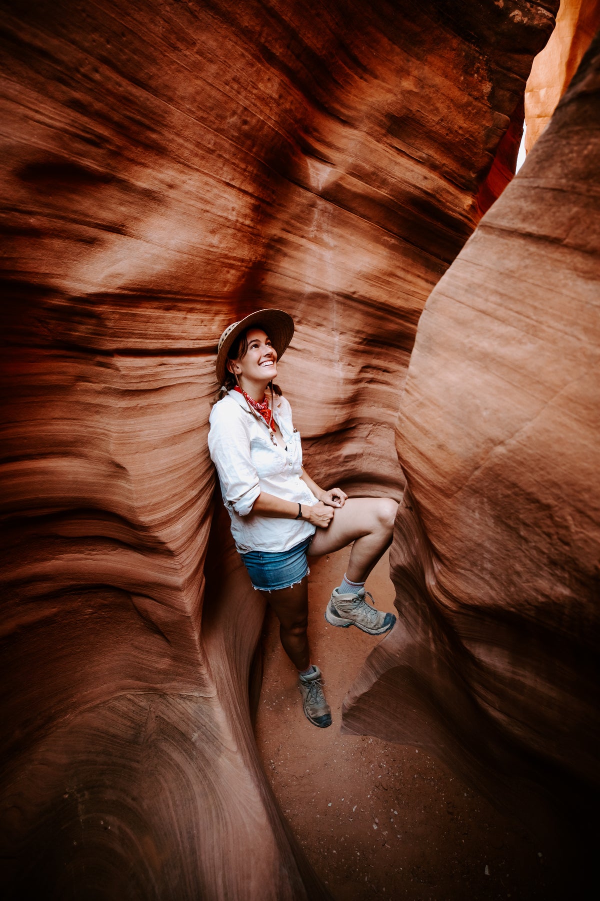 Woman in a Laurel Lattice straw hat with leather chin strap, hiking in a slot canyon - model