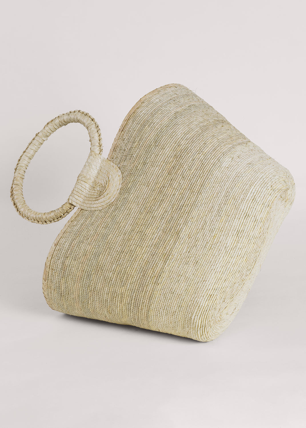 Light palm straw tote with circular woven handles, hand-woven artisan design.