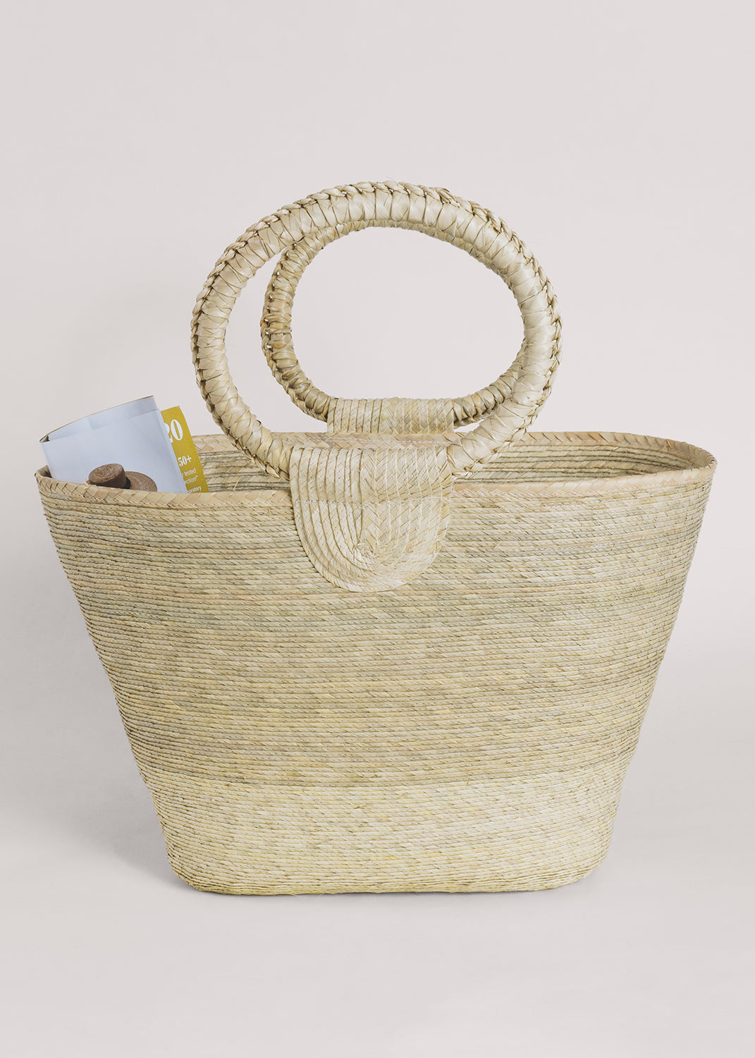 Hand-woven Rosita palm straw tote with circular handles and light, natural color.