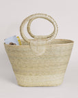 Hand-woven Rosita palm straw tote with circular handles and light, natural color.